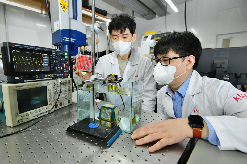 연구의 제1저자인 KIST 전자재료연구센터의 허성훈 박사(좌)와 김현수 학생연구원(우)이 개발한 전자 소자기기를 물속에 설치하여 초음파를 수신해 전기에너지로 변환해 LED 불빛을 밝히는 실험을 하고 있다.